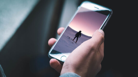 Download Black iPhone in male Hand Mockup | Mockup World